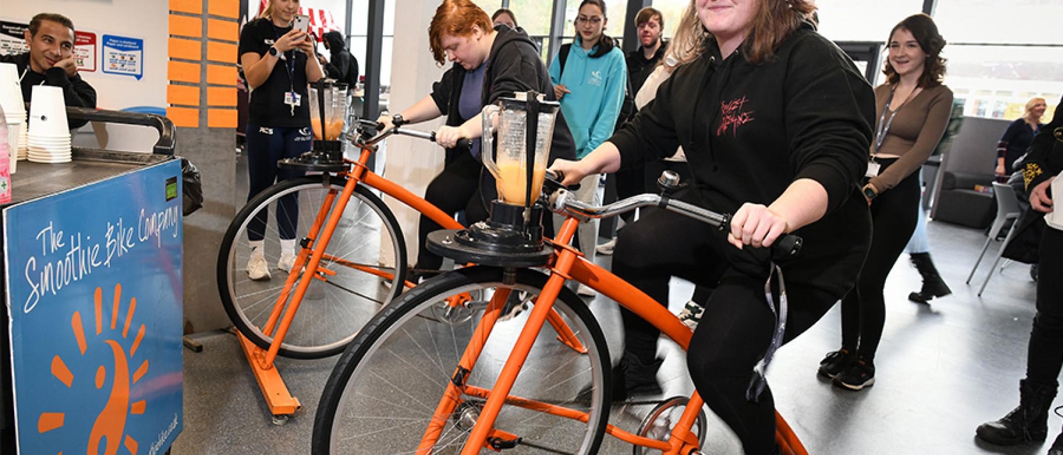 Students riding a stationary bike to blend a smoothie